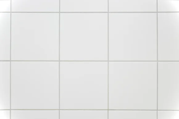 Gekachelte Wand mit weißen Fliesen.